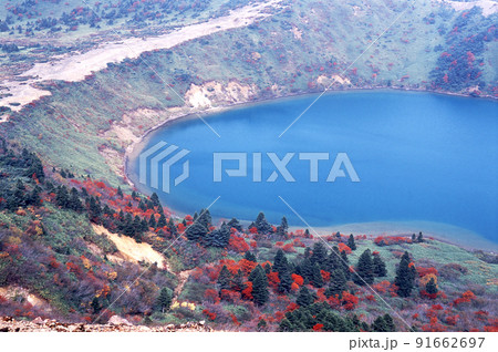 福島県、浄土平から岩山を登り魔女の瞳と呼ばれる五色沼を見下ろす。紅葉と鮮やかなブル-の湖面が綺麗 福島県、浄土平から岩山を登り魔女の瞳と呼ばれる五色沼を見下ろす。紅葉と鮮やかなブル-の湖面が綺麗 91662697