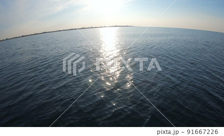 Seascape, view of sea waves with sun reflection from prow of motorboat. Boat jumping on waves on sunny summer day. Yacht motor boat sailing fast at sea horizon. Extreme sport entertainment background 91667226