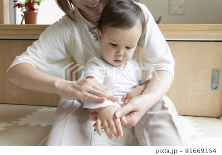 こどもの腕をウェットティッシュで拭くイメージ 91669154