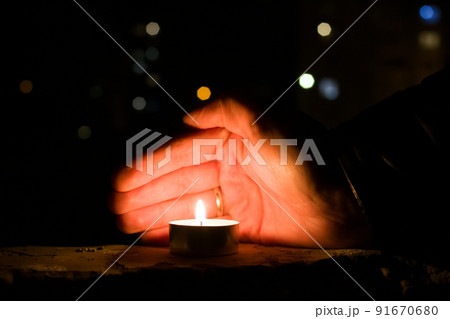 Palm closes the candle in the dark Palm closes the candle in the dark 91670680
