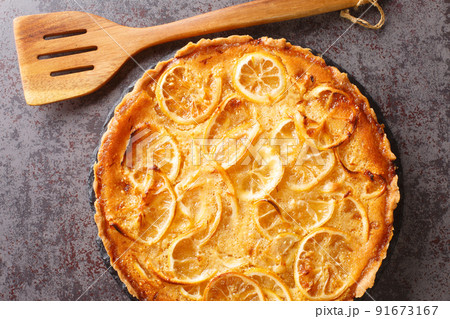 Lemon tart with delicate sweet and sour cream and pieces of fruit close-up in a plate. horizontal top view Lemon tart with delicate sweet and sour cream and pieces of fruit close-up in a plate. horizontal top view 91673167