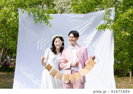 Korean Asian couple self small wedding concept in spring_holding decorative garland Korean Asian couple self small wedding concept in spring_holding decorative garland 91675889