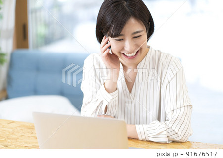テレワークする若い女性　ビデオ通話する女性 91676517