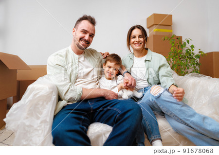 Young parents and son having fun during moving day to new house 91678068
