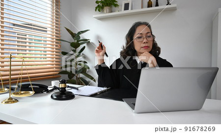 Professional female lawyer having video conference, discussing work via virtual remote meeting on laptop computer at home 91678269