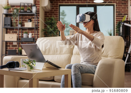 Happy asian woman enjoying wearing VR virtual reality headset, modern glasses technology headset future device gadget digital entertainment game simulation Happy asian woman enjoying wearing VR virtual reality headset, modern glasses technology headset future device gadget digital entertainment game simulation 91680809