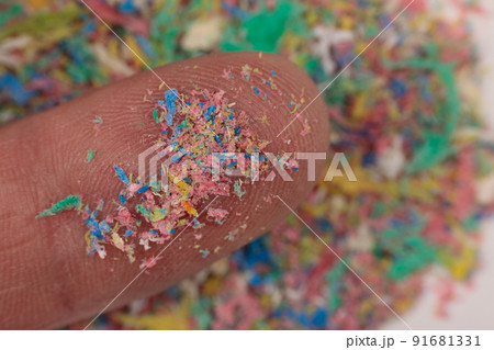 Small plastic pellets on the finger. Close-up of micro plastic as environmental pollution. 91681331