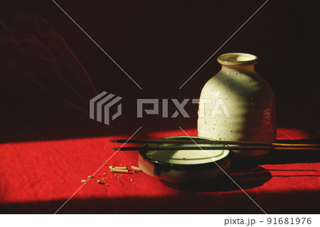 Light and shadows cast on a porcelain container and incense sticks showing the concept of meditation, mindfulness and mental wellbeing Light and shadows cast on a porcelain container and incense sticks showing the concept of meditation, mindfulness and mental wellbeing 91681976