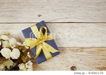 Gift box with pink ribbon with space copy on wooden background 91682170