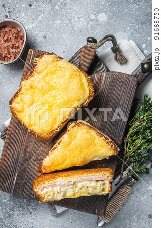 French Croque Monsieur sandwich with Cheese, Ham, Gruyere and Bechamel Sauce. Gray background. Top view French Croque Monsieur sandwich with Cheese, Ham, Gruyere and Bechamel Sauce. Gray background. Top view 91683750