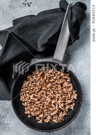 Pan fried minced meat to Italian pasta. Gray background. Top view Pan fried minced meat to Italian pasta. Gray background. Top view 91684313