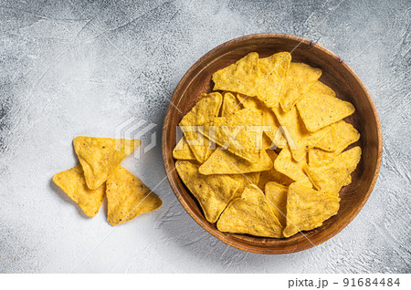 Mexican nachos corn chips in a wooden plate. White background. Top view Mexican nachos corn chips in a wooden plate. White background. Top view 91684484