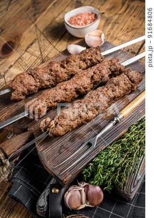 BBQ Grilled Adana kebab on skewers from minced lamb beef meat. Wooden background. Top view 91684806