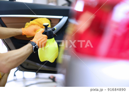 Cropped view of car washer holding rag and aerosol can washing car door Cropped view of car washer holding rag and aerosol can washing car door 91684890