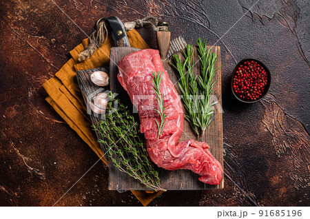 Uncooked beef veal tenderloin, raw meat for fillet mignon steaks. Dark background. Top view Uncooked beef veal tenderloin, raw meat for fillet mignon steaks. Dark background. Top view 91685196