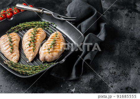 Turkey grilled breast fillet steaks in a frying pan. Black background. Top view. Copy space 91685555