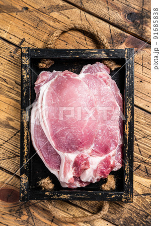 Raw pork cutlet or chop steaks in a wooden tray. Wooden background. Top view Raw pork cutlet or chop steaks in a wooden tray. Wooden background. Top view 91685838