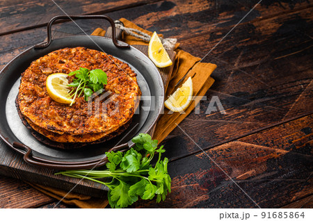 Traditional delicious Turkish foods lahmacun with mince lamb meat in steel tray. Wooden background. Top view. Copy space 91685864