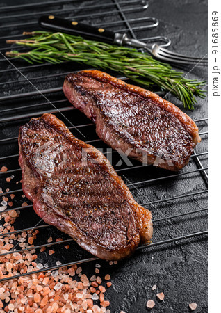 BBQ Grilled cap rump or Top sirloin beef steak, fried meat on grill. Black background. Top view BBQ Grilled cap rump or Top sirloin beef steak, fried meat on grill. Black background. Top view 91685869