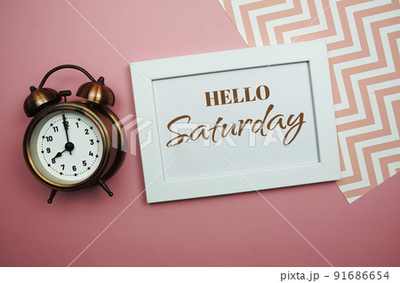 Hello Saturday and Alarm clock on pink background 91686654