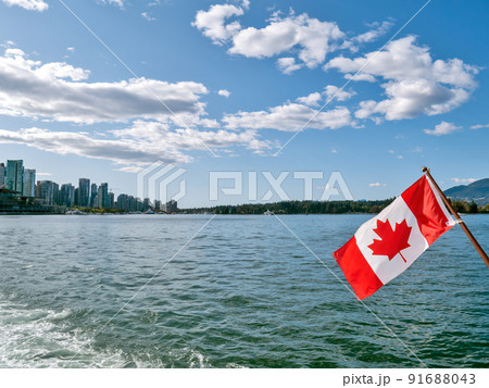 Canadian flag on blue sky and water background in Vancouver harbor 91688043