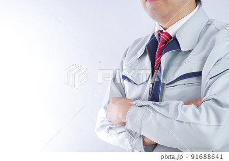 腕組みをする作業服の男性 91688641