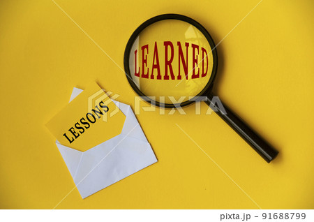 Top view of lessons learned text on envelope and magnifying glass. Learning concept 91688799