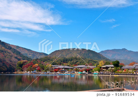 桂川の川面から嵐山公園を経て小倉山へと続く秋の木々の色づき 桂川の川面から嵐山公園を経て小倉山へと続く秋の木々の色づき 91689534