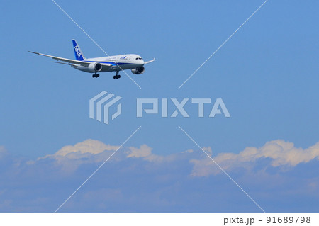 夏空に飛ぶ旅客機　着陸進入する旅客機 91689798