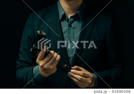拳銃を構えるスーツの人物 拳銃を構えるスーツの人物 91690306