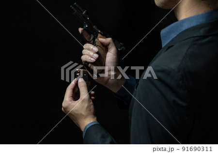 拳銃を構えるスーツの人物 91690311
