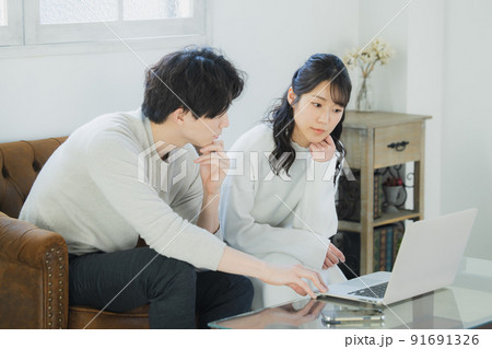 リビングでパソコンを見るカップル 91691326