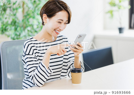 オフィスでスマホを使う女性 91693666