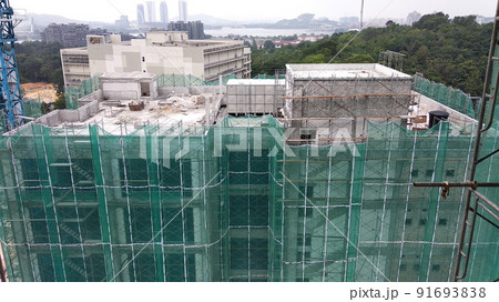 SELANGOR, MALAYSIA -JULY 16, 2018: Safety netting is installed at the high rise building exterior scaffolding during construction. Its avoid building object falling directly to the ground. SELANGOR, MALAYSIA -JULY 16, 2018: Safety netting is installed at the high rise building exterior scaffolding during construction. Its avoid building object falling directly to the ground. 91693838