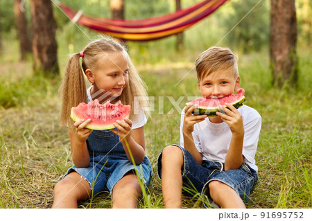 Kids eating watermelon in the park. 91695752