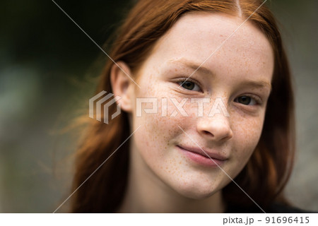 Red haired twelve year old girl with freckles posing with a city bokeh background Red haired twelve year old girl with freckles posing with a city bokeh background 91696415