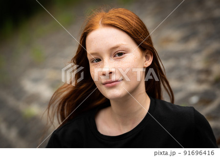 Red haired twelve year old girl with freckles posing with a city bokeh background Red haired twelve year old girl with freckles posing with a city bokeh background 91696416
