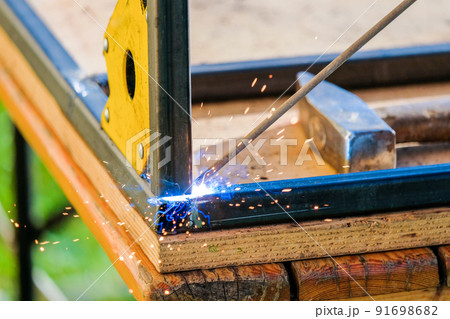 The tip of the electrode of electric arc welding melts the metal.  91698682
