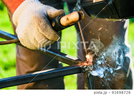 A bright flash of an electric arc between the electrode and the metal. A bright flash of an electric arc between the electrode and the metal. 91698726