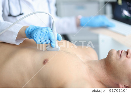 Doctor holding ultrasound machine on man chest in clinic Doctor holding ultrasound machine on man chest in clinic 91701104
