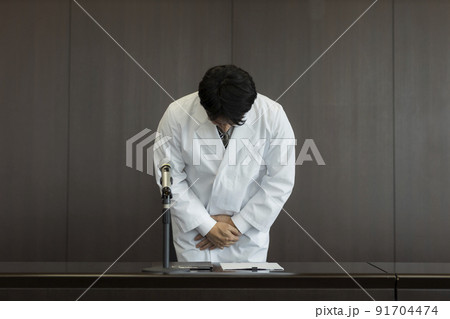 謝罪会見をする白衣の男性 医師 医者 91704474