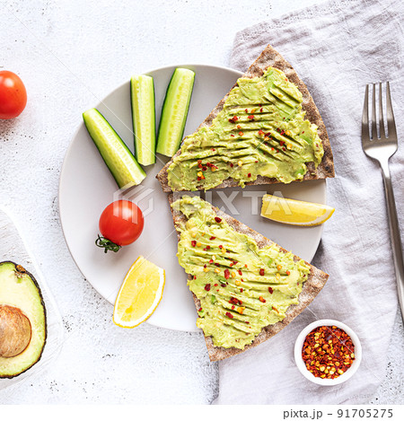 Crisp bread sandwiches with mashed avocado and cucumber 91705275
