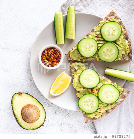Crisp bread sandwiches with mashed avocado and cucumber 91705276