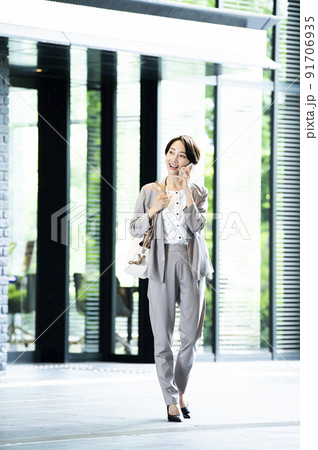 女性　ビジネス　オフィスビル　エントランス　スマホ 91706935