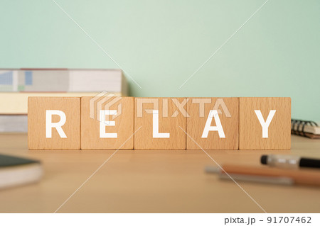 リレー・中継のイメージ｜「RELAY」と書かれたブロックが置かれたデスク 91707462