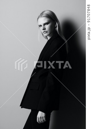 Young beautiful stylish girl posing leaning on the wall in the studio 91707848