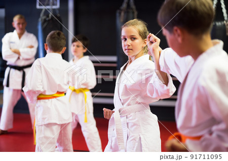 Children practicing new karate moves in pairs Children practicing new karate moves in pairs 91711095