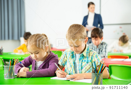 Assiduous kids studying in classroom 91711140