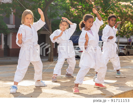 Kids in kimono doing kata outdoors Kids in kimono doing kata outdoors 91711153
