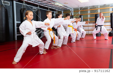 Children wearing karate uniform fighters poses in kimono, group training 91711162